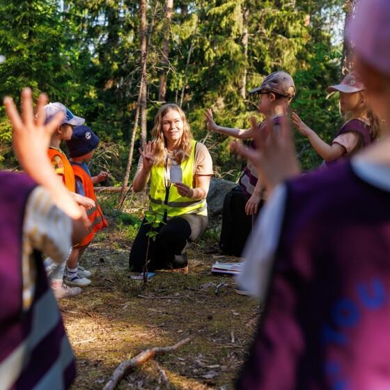 Varhaiskasvatuksen opettaja metsäretkellä lapsiryhmän kanssa.